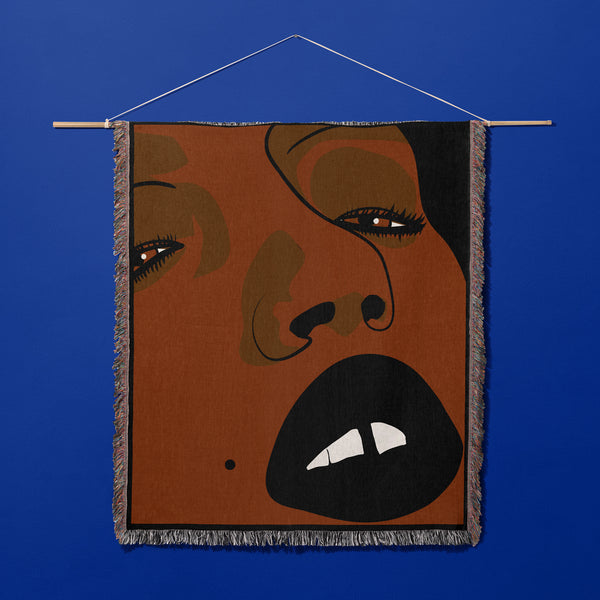 About Face Throw  close up of brown face with dark painted  lips and a small gap in the teeth hanging from hanger